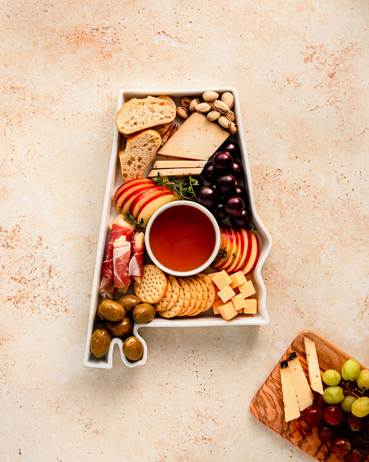 charcuterie board with cheese and cured meats in a alabama shaped serving tray