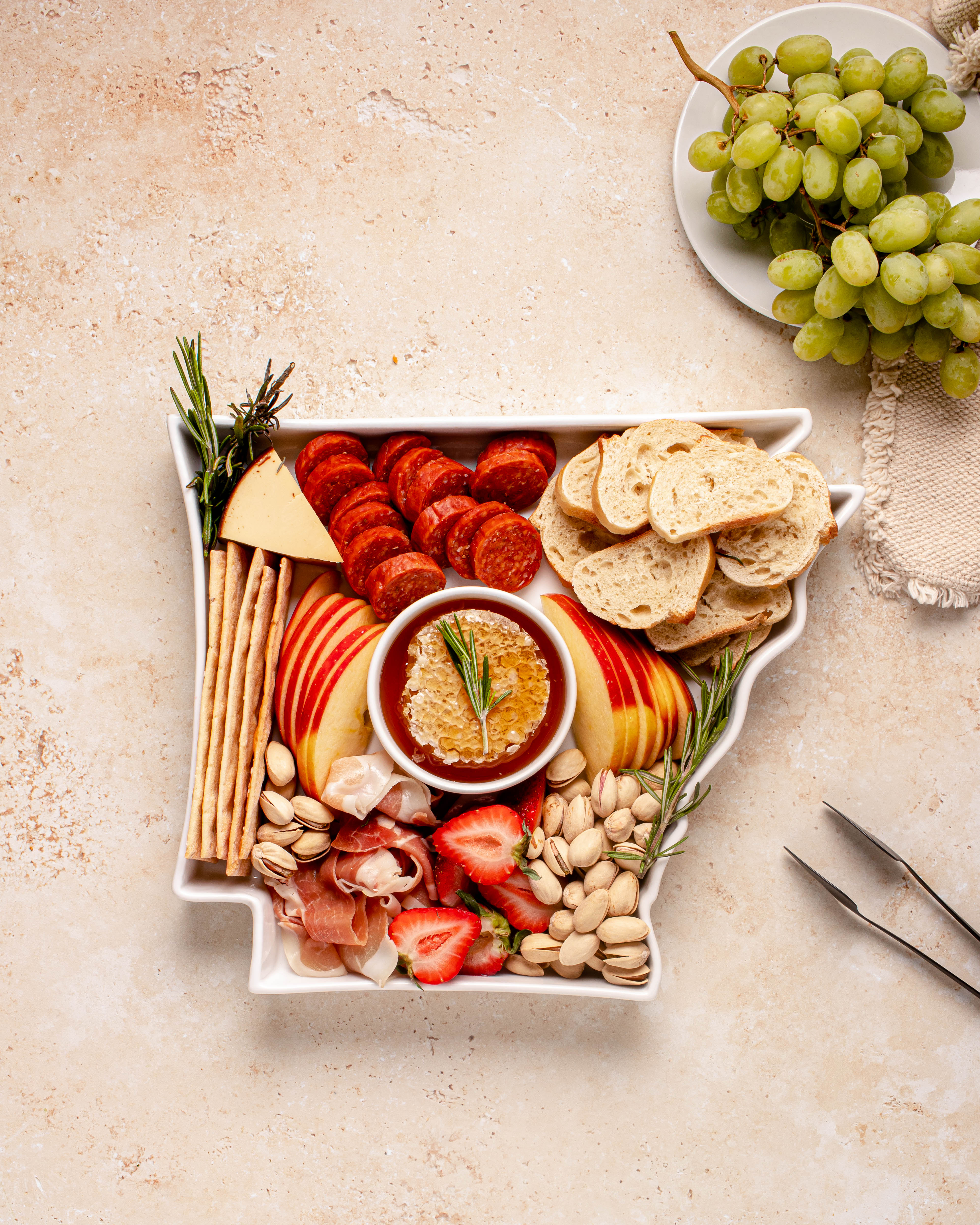 charcuterie board with cheese and cured meats in a arkansas shaped serving tray platter dish