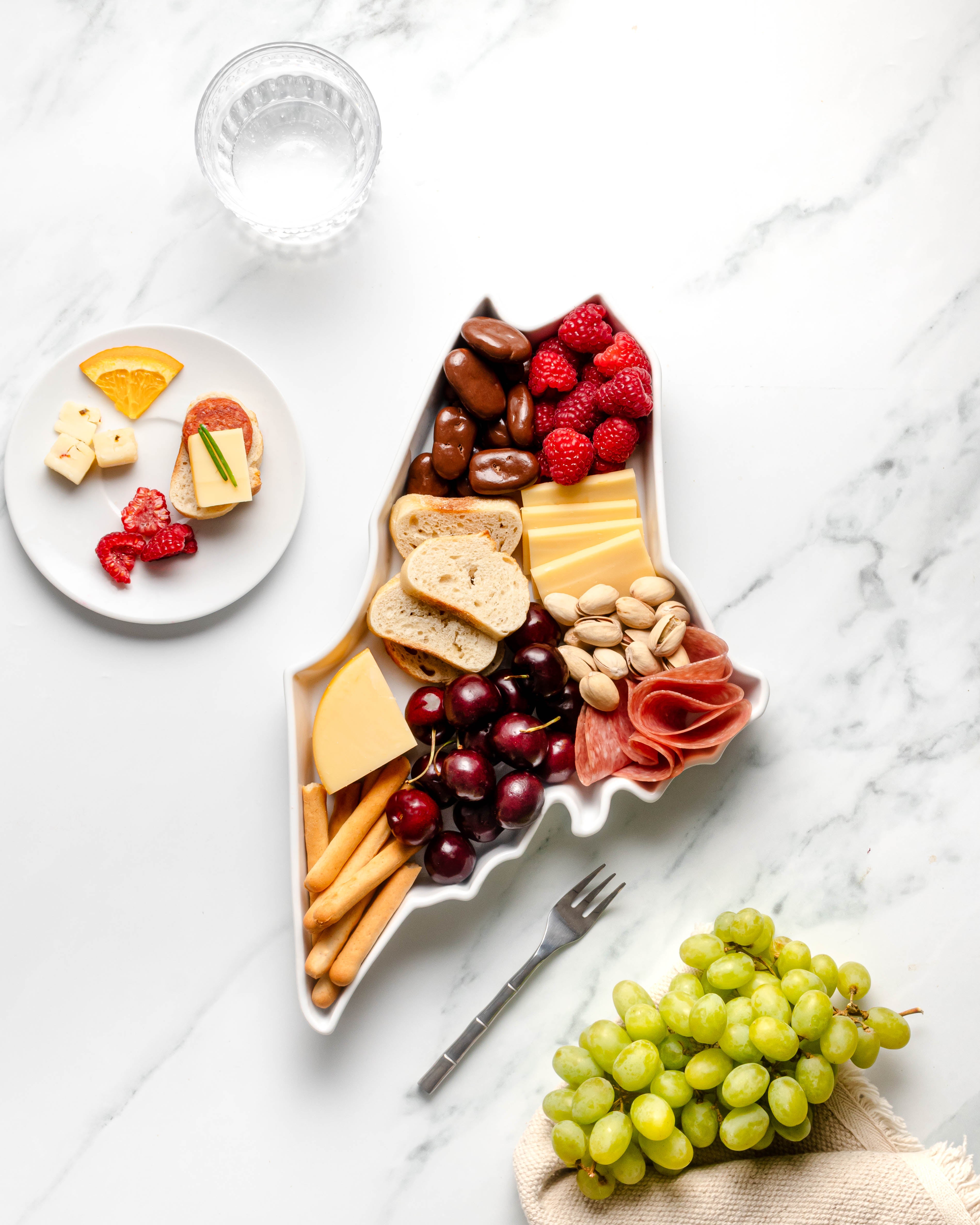 charcuterie board with cheese and cured meats in a Maine shaped serving tray platter dish