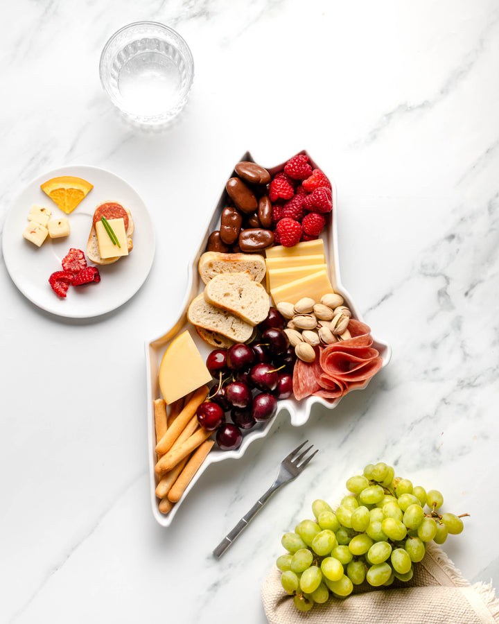 charcuterie board with cheese and cured meats in a Maine shaped serving tray platter dish