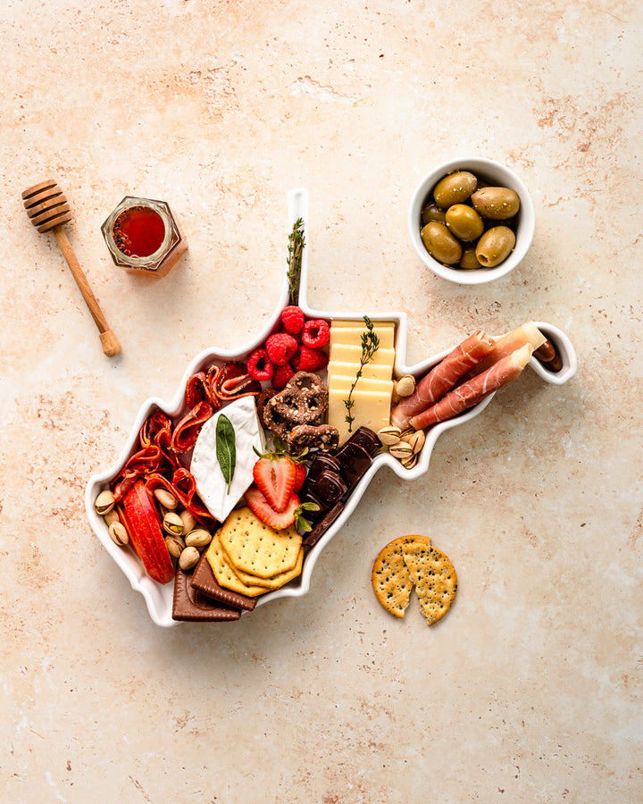 charcuterie board with cheese and cured meats in a West Virginia shaped serving tray platter dish