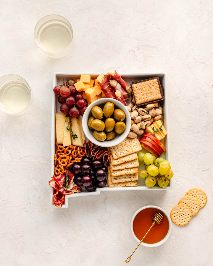charcuterie board with cheese and cured meats in a New Mexico shaped serving tray platter dish